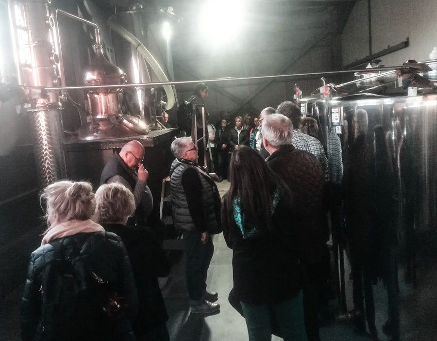 tourists listening to a woman giving a tour at 'Dorodouli Tsipouro' plant
